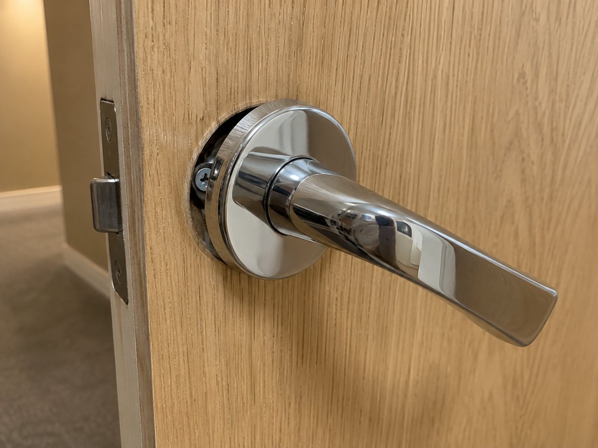Photo fictive générée : rosace d’une poignée de porte desserrée.
